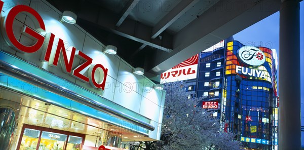 JAPAN, Honshu, Tokyo, Ginza District. City architecture with large advertising signs illuminated at dusk