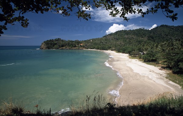 THAILAND, Krabi, Koh Lanta Yai, Klong Jark or Waterfall Bay seen through trees with waves rolling ashore