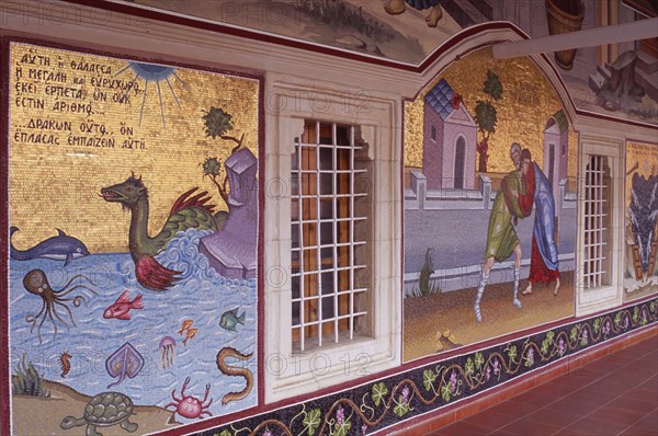 CYPRUS, Troodos Mountains, Kykko Monastery, Detail of brightly coloured mosaics and paintings covering exterior wall of covered walkway.