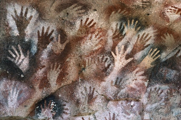 ARGENTINA, Patagonia, Cueva de las Manos, "Cave of the Hands.  Prehistoric rock paintings of human hands in red black and orange 13,000 to 9,500 years old."
