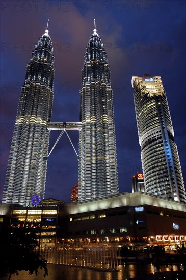 MALAYSIA, Kuala Lumpur, Angled view looking up at the Petronas Twin Towers illuminated at night