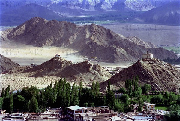 INDIA, Ladakh, Leh, View toward distant hilltop Temples on the outskirts of the town against a backdrop of mountains