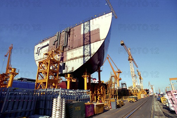 SOUTH KOREA, Pusan, Dae-woos new ship building yard with ship section raised on scaffolding surrounded by cranes