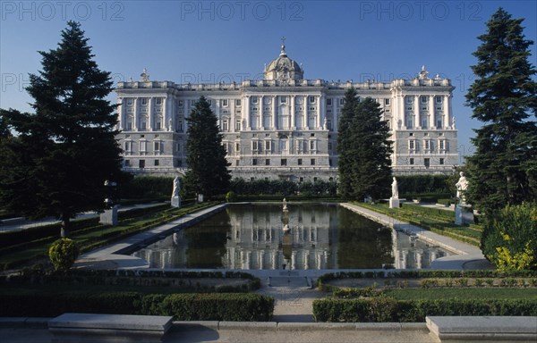 SPAIN, Andalucia, Cordoba, Alcazar de los Reyes Cristianos gardens with long pond bordered with flowers and tall clipped trees and modern sculpture in the foreground