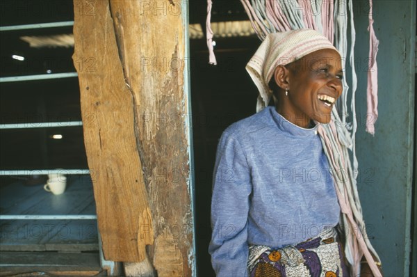 TANZANIA, Kisongo, Arusha, "Kisongo Masai market outside Arusha.  Portrait of Pauline, owner of small teahouse, laughing in doorway."