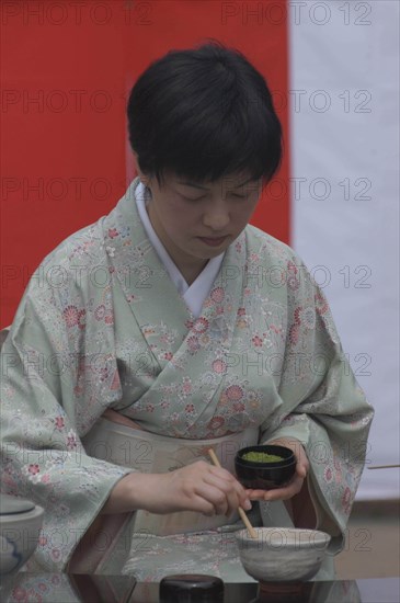 JAPAN, Chiba, Yokaichiba, "Licensed tea master, Chiharu Koshikawa, prepares green tea, ""macha"" at a tea ceremony and  places ""macha"" green tea powder in bowl"