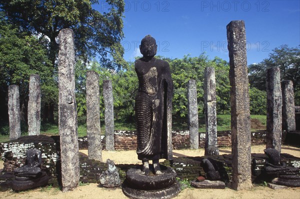 SRI LANKA, Polonnaruwa, The Atadage. Standing Buddha statue among stone columns within the quadrangle