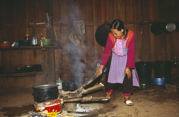 THAILAND, Chiang Mai Province, Chiang Dao District, Young Lisu woman working in her kitchen in Bahn Mai Phaem