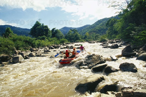 THAILAND, Chiang Mai Province, Western tourists and Thai guides white water river rafting on the Mae Taeng River