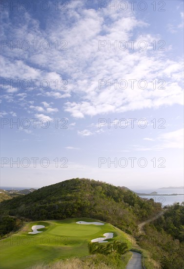 WEST INDIES, St Vincent & The Grenadines, Canouan, Raffles Resort showing the 12th green on the Trump International Golf course with the southern Grenadine islands in the distance