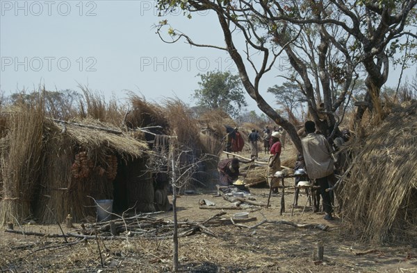 BURUNDI, Architecture, Hutu village dwellings with women cooking over open fire.