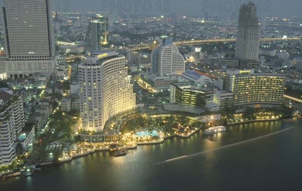 THAILAND, Bangkok, Aerial view of the Skyline. Large Hotel with swimming pool and boats next to the Chaophraya River
