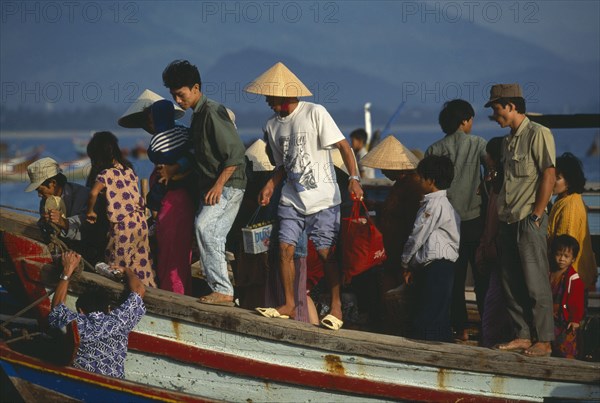 VIETNAM, Nha Trang, People from offshore islands disembarking from ferry at shore at Cau Dua fishing village on the south end of Nha Trang Beach