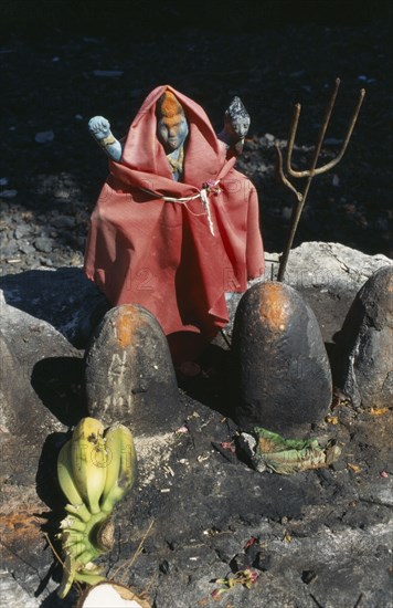 MAURITIUS, Religion, Hindu, Decorated figure in Hindu shrine with offerings of fruit and flowers.