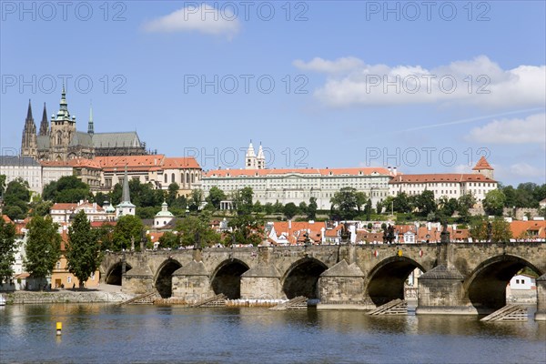 CZECH REPUBLIC, Bohemia, Prague, View across the Vtlava River to Charles Bridge with St Vitus cathedral in Prague Castle on the hilltop of Hradcany