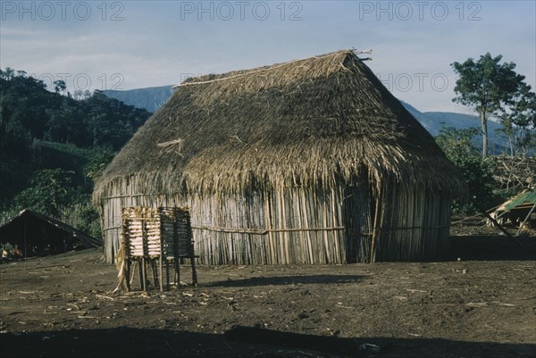 COLOMBIA, Sierra de Perija, Yuko - Motilon, Old thatched dwelling in foreground with shelter for drying maize behind in Yuko-Motilon village.