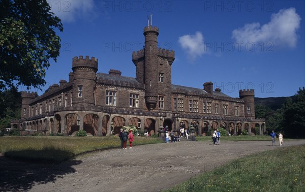 SCOTLAND, Inverness shire, Isle of Rum, Kinloch Castle exterior with visitors in grounds. Built in 1901 as a shooting lodge and is currently a hotel.