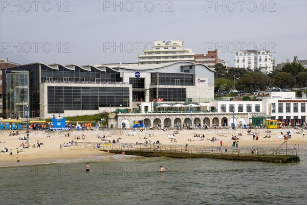 ENGLAND, Dorset, Bournemouth, The Imax Complex on the seafront with people on the beach and in the water by a small pier jetty