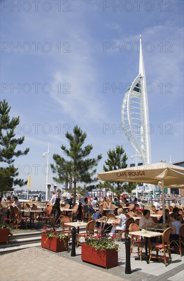 ENGLAND, Hampshire, Portsmouth, The Spinnaker Tower the tallest public viewing platforn in the UK at 170 metres on Gunwharf Quay with outdoor restaurant seating in the foreground