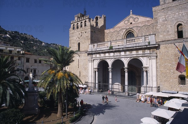 ITALY, Sicily, Palermo, Monreale. II Duomo Norman Cathedral exterior with people walking on road near small market stalls