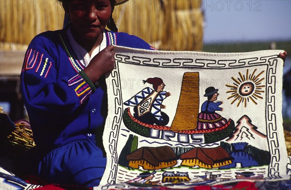 PERU, Puno Administrative Department, Lake Titicaca, "Uros floating islands/Aymara woman. The Aymara women who inhabit the floating reed islands of Uros on Lake Titicaca, make a living from tourism: selling hand made trinkets and patterned wall hangings"