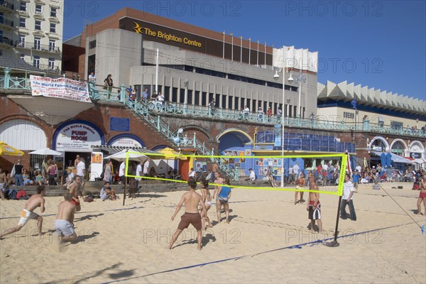 ENGLAND, East Sussex, Brighton, People playing beach volleybal on the sands in front of the Brighton Centre.