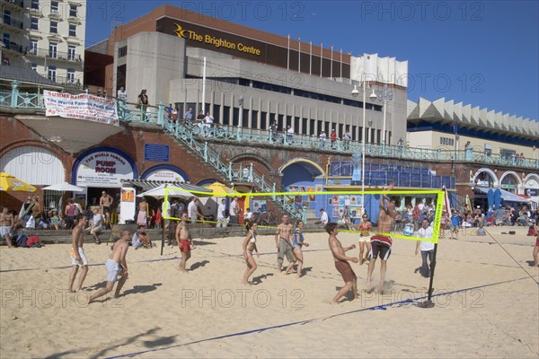 ENGLAND, East Sussex, Brighton, People playing beach volleybal on the sands in front of the Brighton Centre.