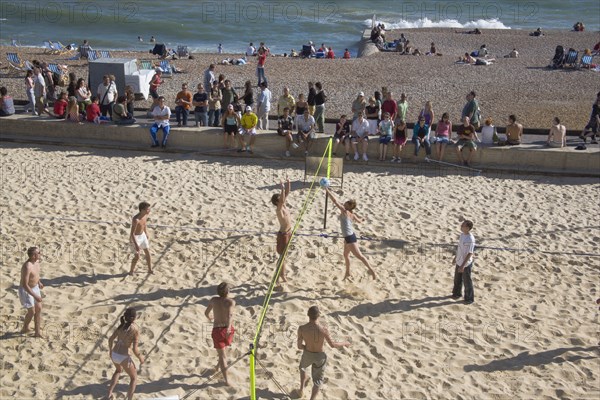 ENGLAND, East Sussex, Brighton, Beach volleyball game on the sands in front of the Grand Hotel.