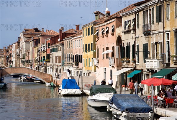 ITALY, Veneto, Venice, Fondamenta Degli Ormesini in Cannaregio district with boats moored along the canal and people walking along the pavement