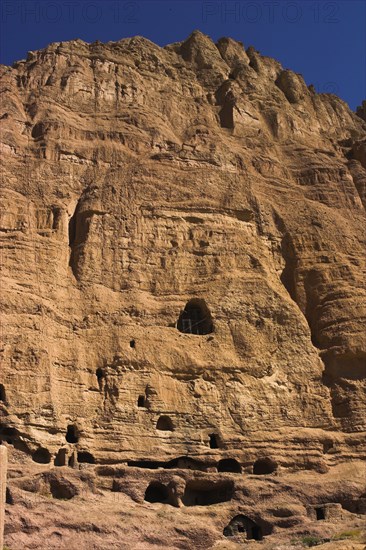 AFGHANISTAN, Bamiyan Province, Bamiyan , Caves in cliffs near empty niche where the famous carved small Budda once stood 180 foot high before being destroyed by the Taliban in 2001