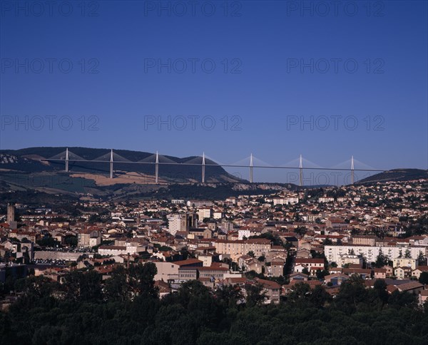 FRANCE, Midi-Pyrenees, Aveyron, Millau.  Cityscape with Millau bridge beyond which carries the A75 motorway from Beziers to Clermont Ferrand.