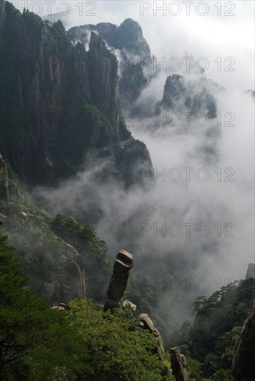 CHINA, Anhui Province, Huang Shan , Huangshan or the Yellow Mountain. Rock peaks with lush green pine trees and a sea of cloud. Has inspired countlless painters and poets over the ages and has a 1200-year history as a tourist attraction
