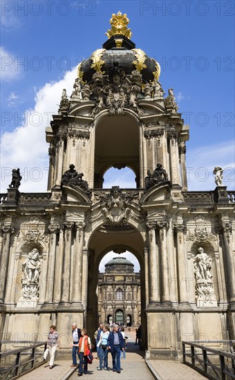 GERMANY, Saxony, Dresden, The Crown Gate or Kronentor of the restored Baroque Zwinger Palace with tourists walking through originally built between 1710 and 1732 after a design by Matthäus Daniel Pöppelmann in collaboration with sculptor Balthasar Permoser.