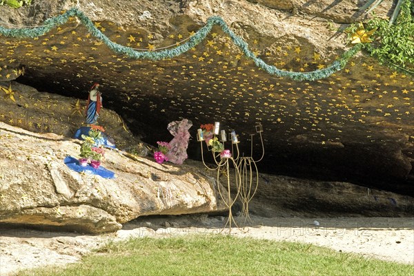 Rio de Janeiro, Brazil. Grotto in rocks in Arpoador Park off Ipanema beach with statue of Jesus Christ gold stars flowers and a wire candle holder. Brazil Brasil Brazilian Brasilian South America Latin Latino American City Urban Beach Grotto Statue Religous Reilgion Christian Christianity Gold Stars Ipanema Arpoador Altar Worship Candles Destination Destinations Latin America Religion Religion Religious Christianity Christians Sand Sandy Beaches Tourism Seaside Shore Tourist Tourists Vacation South America Southern