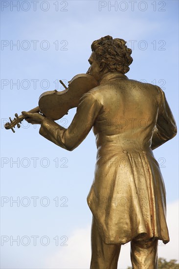 Vienna, Austria. Johann Strauss statue in the Stadtpark. Austria Austrian Vienna Wien Viennese Republic Austro-Bavarian Wean Europe European City Capital Travel Destination Art Statue Stadpark Park Public Johann Strauss Violin Gold Blue Clouds Cloud Sky Color Destination Destinations Osterreich Viena Western Europe