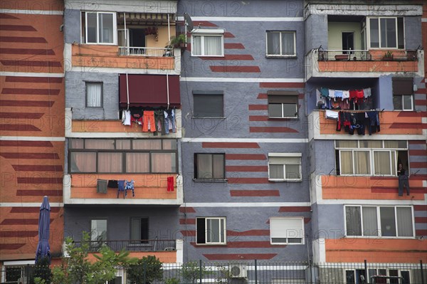 Albania, Tirane, Tirana, Colourful apartment buildings  part view of exterior facade with washing hanging from balconies.