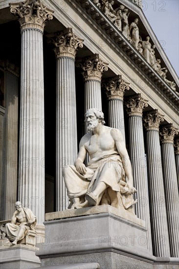 Part view of colonnaded exterior of the Parliament building with statue of the Greek philosopher Thucydides in foreground. Photo : Bennett Dean