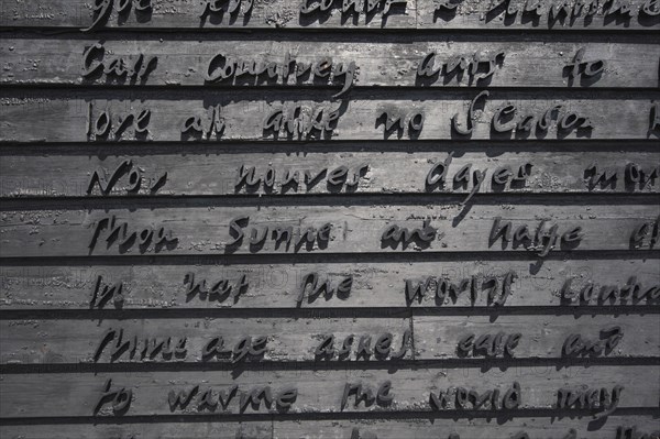 Detail of building gable wall with words carved from wood.